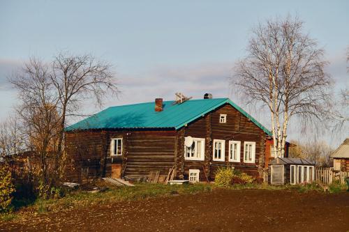 Värske akvamariinivärviline plekk-katus  eelmise sajandi esimesel poolel ehitatud elamul Kulömdini alevikus Komimaal.